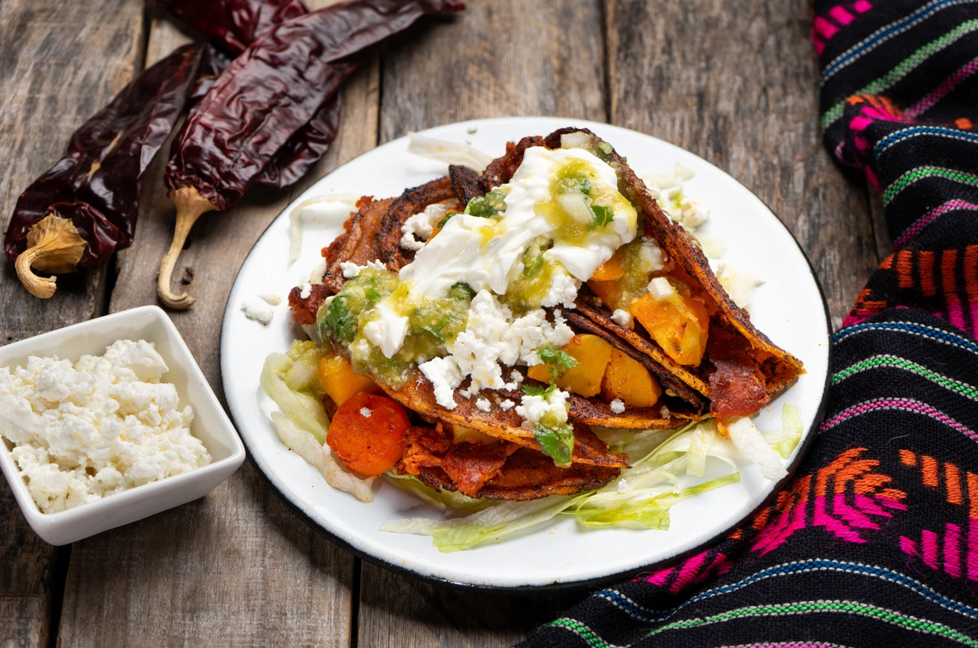Mexican red enchiladas with potato and pork chorizo also called Potosinas on wooden background